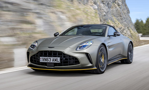 Der Aston Martin Vantage Roadster (2025) fahren auf einer Straße von seitlich vorne.