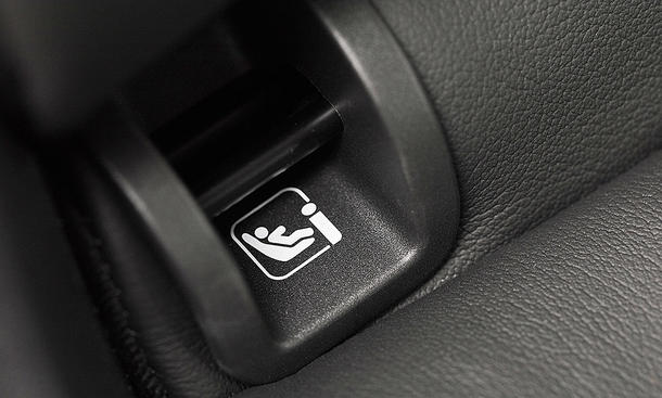 Das Bild zeigt einen Isofix-Aufnahmepunkt in der Rückenlehne einer Rückbank in einem Auto.