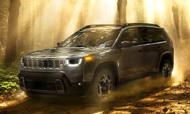 Man sieht den Jeep Cherokee (2025) durch einen Wald fahren.