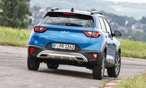 Der Kia Stonic (2020) fährt auf der Landstraße; von schräg hinten fotografiert.