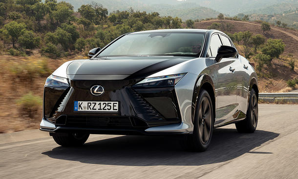 Der Lexus RZ fährt über eine Landstraße, fotografiert von schräg vorne.