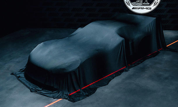 Blick von schräg vorne auf den noch unter Tüchern gehüllten Sportwagen Mercedes-AMG Concept AMG GT Track Sport.