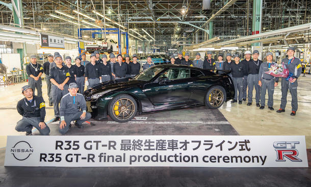 Der Nissan GT-R in einem Werk, umringt von Mitarbeitenden. 