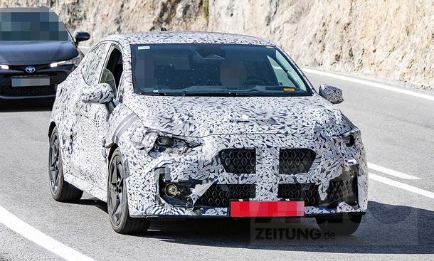 Der Renault Clio (2025) als Erlkönig getarnt fahrend von vorne fotografiert.