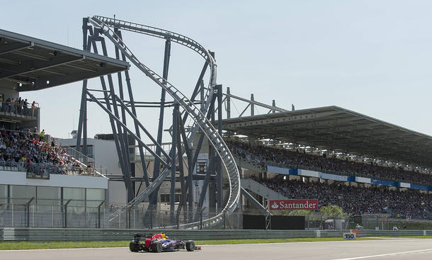 Ein Rennfahrzeug vor dem Ring Racer, daneben sieht man die Tribüne des Nürburginges.