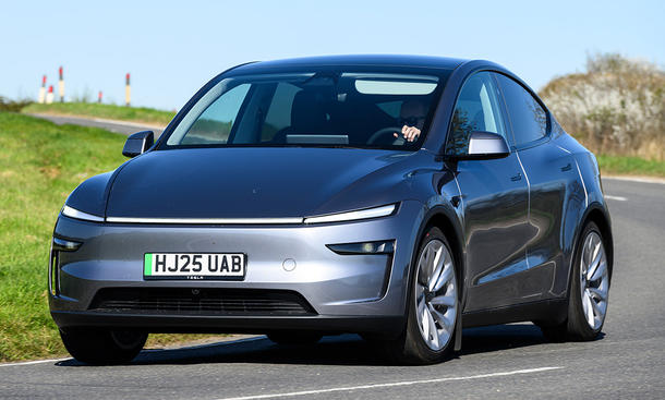 Das Tesla Model Y Facelift (2025) fährt in eine Kurve, von schräg vorne fotografiert.